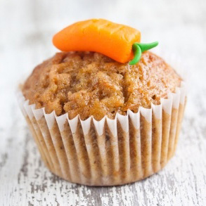 A muffin with a carrot piped on top in icing.
